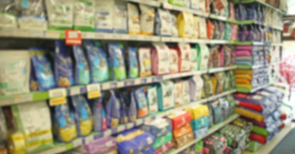Shelves of packaged pet food and accessories in a pet shop